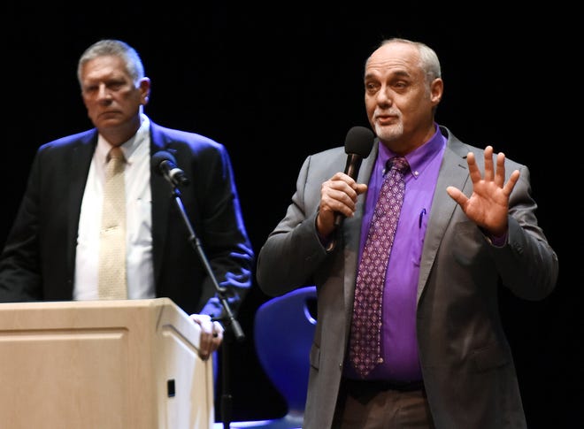 Streetsboro Mayor Glenn Broska, left, listens to his opponent Jeff Allen at a debate at the Streetsboro High School on Wednesday.