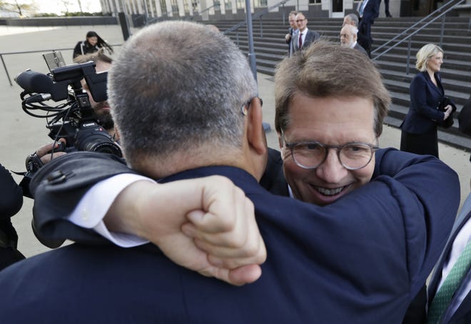 Attorney Mark Lanier gets a hug outside the U.S. Federal courthouse, Monday, Oct. 21, 2019, in Cleveland. The nation's three dominant drug distributors and a big drugmaker have reached a $260 million deal to settle a lawsuit related to the opioid crisis just as the first federal trial over the crisis was due to begin Monday. (AP Photo/Tony Dejak)