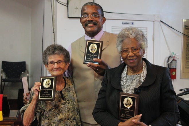 Pastor Ronald Foxx, center, pastor of Shady Grove Primitive Baptist Church in the Porters community, awards activist Carol Thomas, left, with the Social Justice and Equality Award and Janie Williams, right, with the Distinguished Service Award at the church Saturday during a ceremony reminding the community the church was officially listed on the National Register of Historic Places in 2005. [PHOTOS BY VOLEER THOMAS/SPECIAL TO THE GUARDIAN]

.