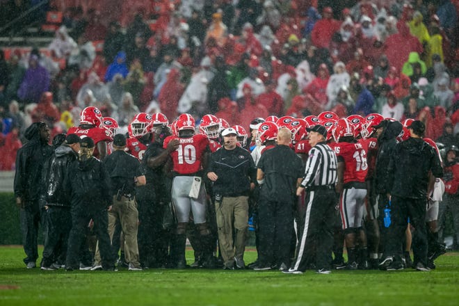 Georgia huddles up during last week's 21-0 win over Kentucky in the middle of a driving rain from tropical storm Nestor. [Photo/Ken Ward Contributor, Athens Banner-Herald]