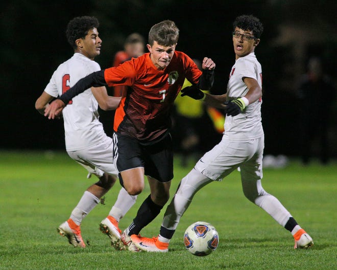 Tecumseh boys soccer junior Aidan Cornish, breaks through the defense of Melvindale's Saleh Said (6) and Mohamed Alratan during Wednesday's Division 2 soccer regional game played in Novi. The Indians suffered a season-ending 3-1 loss in the battle.