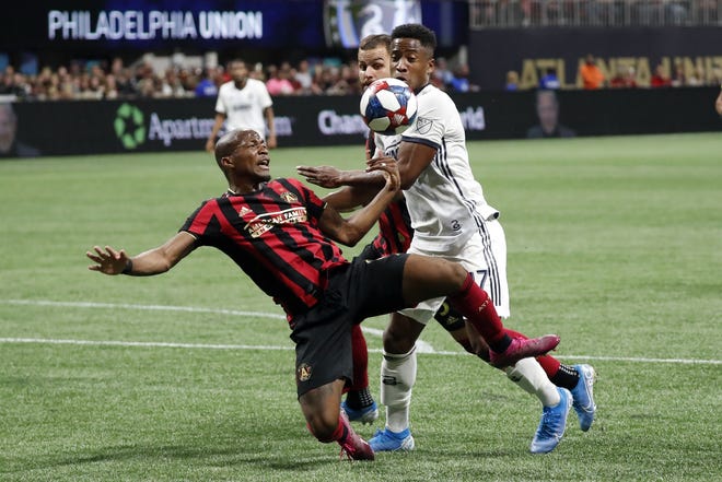 Philadelphia Union forward Sergio Santos, right, and Atlanta United midfielder Darlington Nagbe compete for the ball in front of the net during the first half of an MLS soccer Eastern Conference semifinal Thursday in Atlanta. [JOHN BAZEMORE/THE ASSOCIATED PRESS]