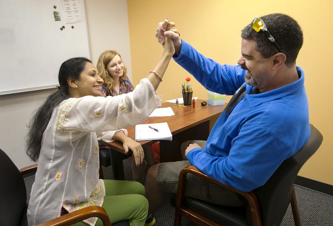 Shilpa Shamapant, co-founder and president of the nonprofit Austin Speech Labs, left, high-fives longtime client Casey Gwinn as he just finished 16-weeks of research therapy. Leah von Hee is a speech language pathologist clinical fellow and was assisting in the testing of Gwinn. [AMERICAN-STATESMAN 2016]