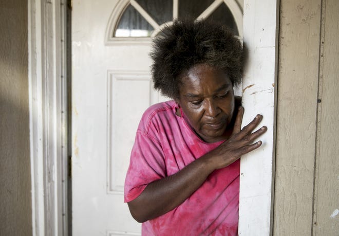 Katrina Johnson stands in the doorway of her Dallas home in August, moments after her uncle was overcome by the heat and transported by ambulance to a hospital. The family has been trying to conserve energy after the power was cut off several times in recent years. [JAY JANNER/AMERICAN-STATESMAN]