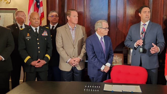 Secretary of State Frank LaRose (right) makes a point during a bill-signing cermony at the Statehouse on Friday creating the cyber reserve as part of the Ohio National Guard. From left are Adjutant General John Harris Jr., Lt. Gov. Jon Husted and Gov. Mike DeWine. The volunteer reserve will respond to attacks on government computer networks, incuding elections systems. [Randy Ludlow/Dispatch]