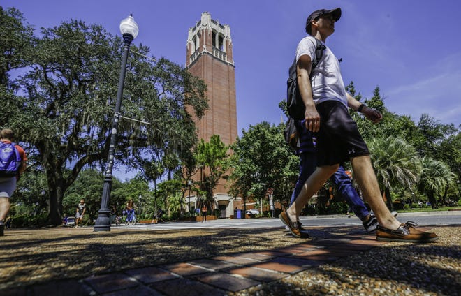 Students walk through the University of Florida campus with Century Tower in the background. [Gainesville Sun, File]