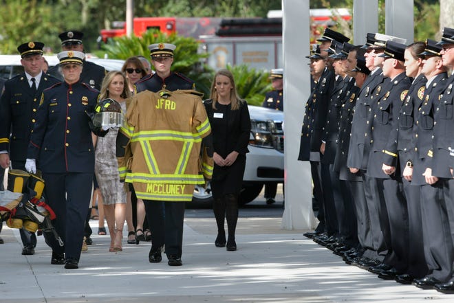 Firefighters carry the gear of fellow firefighter Brian McCluney as they are followed by family members Friday during a celebration of his life at North Jax Baptist Church. McCluney and Virginia firefighter friend Justin Walker went missing after an Aug. 16 fishing trip off the Port Canaveral coast. [Will Dickey/Florida Times-Union]