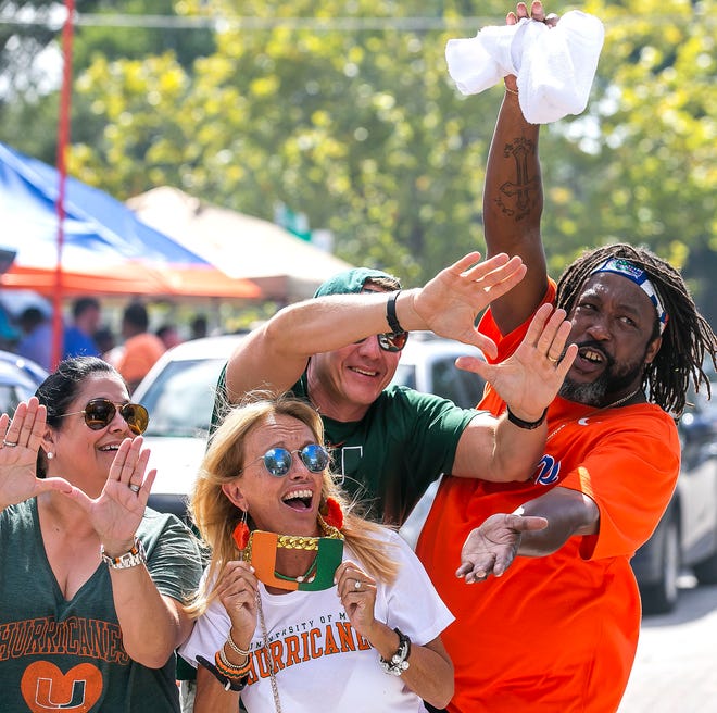 University of Florida fan Aaron Baker of Orlando, right, breaks up a Miami fan group while tailgating at Camping World Stadium in August ahead of the Florida-Miami football game. [ DOUG ENGLE/GATEHOUSE MEDIA SERVICES ]