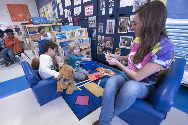 A teacher works with children during a pre-K class. [StarNews]