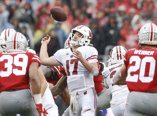 Wisconsin Badgers quarterback Jack Coan (17) fumbles the ball after being pressured by Ohio State Buckeyes defensive end Chase Young (2) during the third quarter of the NCAA football game at Ohio Stadium in Columbus, Ohio on Saturday, Oct. 26, 2019. Ohio State won 38-7. [Adam Cairns/Dispatch]