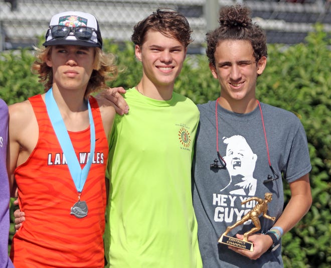 Lake Wales runner Andy Denton, center, showed his support of teammate Landon Morales, right, by having Morales accompany him during the awards ceremony after the Class 3A, District 4 cross country meet. Denton was the individual winner and Morales finished fifth but was disqualified. At left is Lake Wales runner Mac Updike, who finished second. [ROY FUOCO/THE LEDGER]