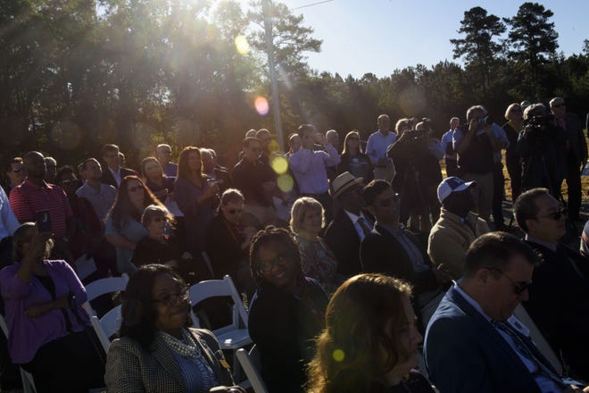 Community members sit in the rising sun while attending a ribbon cutting ceremony for a new community solar farm on Oct.23, 2019. Community Solar is a customer program that provides an alternative to roof-top solar for customers who want to participate in renewable energy.[Melissa Sue Gerrits/The Fayetteville Observer]