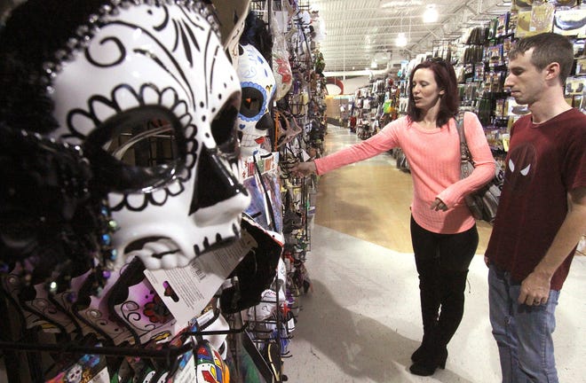 Chris Winslow and Courtney Haynes look over the selection of masks at the Halloween Mega Store in Daytona Beach. [David Tucker/Gatehouse Florida file]