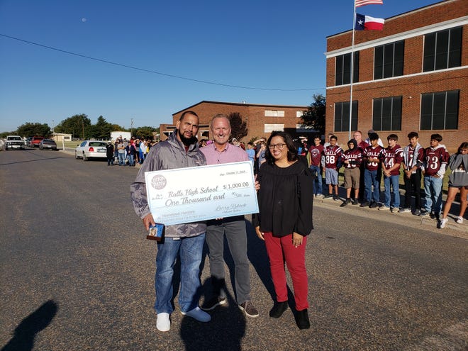 Ralls High School Band Director Kenneth Walker, left, accepted a $1,000 check for his school and prizes for himself as the recipient of Cotton Patch Cafe’s Heroes Circle program. [Photo provided by Cotton Patch]