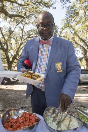 Savannah police Sgt. Maurice Sanders grabs some onions for his hotdog in Daffin Park on Monday. Members of multiple departments and public safety entities in Savannah and Chatham County were treated to a free picnic lunch in the park by local law firm Harris Lowry Manton LLP. This is the sixth year the law firm has held its First Responder Appreciation Luncheon. [Will Peebles/Savannahnow.com]