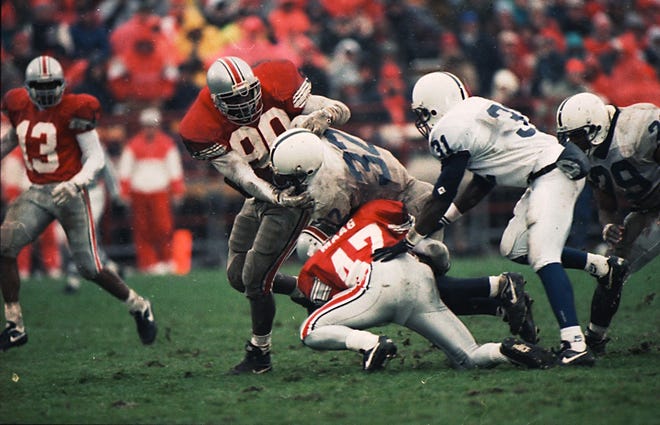 Dennis Maag (47) and Lorenzo Styles bring down Ki-Jana Carter of Penn State in 1993. [ERIC ALBRECHT/DISPATCH]
