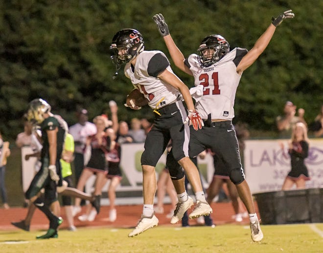 South Sumter's Wyatt Mandahl (11) and Trenton Taylor (21) celebrate after Mandahl scored a fourth-quarter touchdown during a game against The Villages on Oct. 11 in The Villages. [PAUL RYAN / CORRESPONDENT]