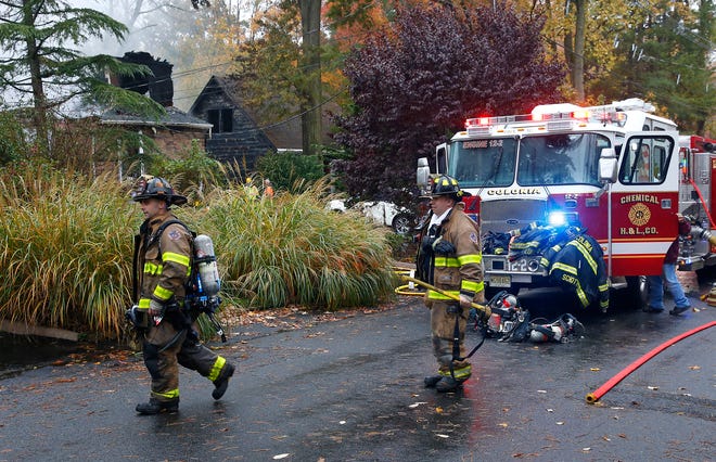 Woodbridge firefighters work the scene of fire after a plane crashed into a home Tuesday in Woodbridge,N.J. [NOAH K. MURRAY/THE ASSOCIATED PRESS]