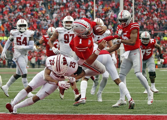 Ohio State Buckeyes quarterback Justin Fields (1) scores a rushing touchdown against Wisconsin Badgers safety Eric Burrell (25) during the 3rd quarter of their game at Ohio Stadium in Columbus, Ohio on October 26, 2019. [Kyle Robertson/Dispatch]