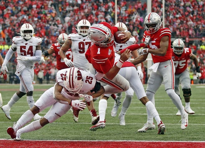 Ohio State Buckeyes quarterback Justin Fields (1) scores a rushing touchdown against Wisconsin Badgers safety Eric Burrell (25) during the 3rd quarter of their game at Ohio Stadium in Columbus, Ohio on October 26, 2019. [Kyle Robertson]