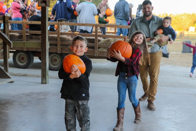 The Roberts family, Elija, 8, Adyson, 8, Nathan, and Nash, 1, carried pumpkins to the scale getting ready for fall. [Tina Brooks / The Daily News]