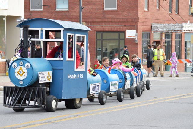 Trick-or-treaters wave from the ‘spooky train’ as it drives down Main Street.