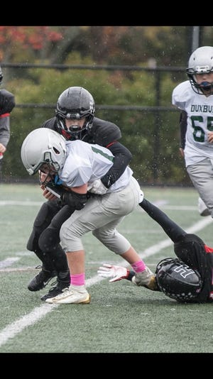 Ryan St. Croix sacks the Duxbury quarterback as Alex Levy assists with the tackle. [Courtesy photo/Josh Ross Photgraphy]