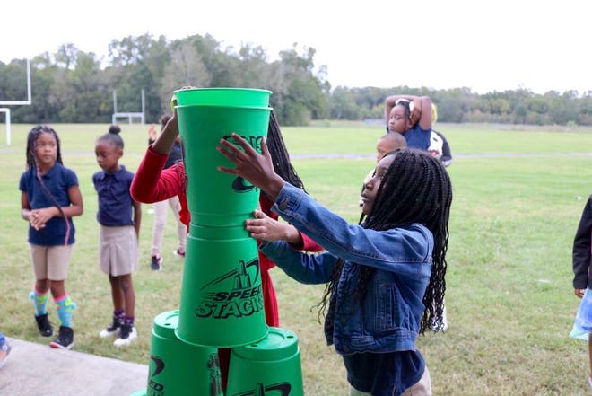 Students participate in a game at the Boys and Girls Club Open House, Oct. 24. This team exercise of stacking cups is one of many they may participate in.