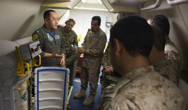Lt. Fan Yang, left, was photographed in 2018 explaining equipment aboard a P-8A Poseidon aircraft. [Mass Communication 2nd Class Jakoeb Vandahlen/U.S. Navy]