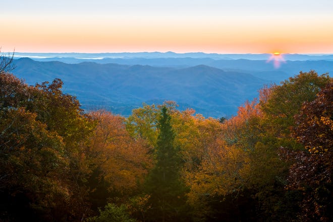The sun rises on a cool autumn morning, as fall color brightens the scenery near Pilot Ridge Overlook on the Blue Ridge Parkway (milepost 301.8). [Photo by Skip Sickler | Grandfather Mountain Stewardship Foundation]