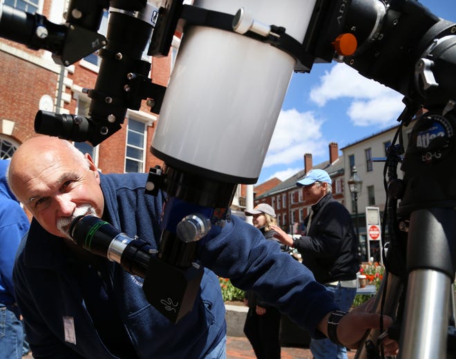 Portsmouth resident Tom Cocchiaro, a member of the New Hampshire Astronomical Society, helps people in Market Square view the last transit of Mercury across the sun in 2016. The transit is happening this year on Monday, Nov. 11. [Rich Beauchesne/Seacoastonline, file]