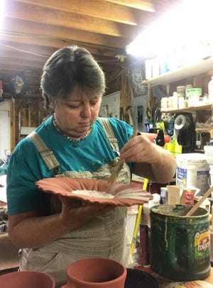 Tricia Woodland gets some pieces ready for the Carolina Pottery Show on Saturday. [Special to The Star]