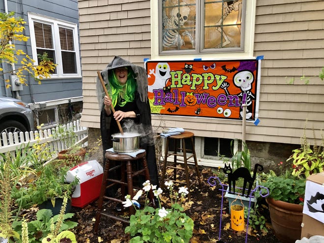 Orlene Hagedorn stirred a cauldron with dry ice in front of her house on Brook Street Oct. 31. [Shayna Scott / BU News Service]