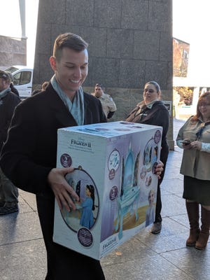Psychic/medium Matt Fraser delivers one of the many toys he purcharsed to load onto the bus at Foxwoods' Stuff the Bus kickoff on Saturday. [Bulletin photos]
