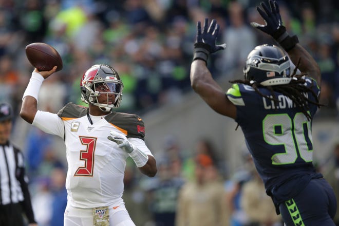 Tampa Bay Buccaneers quarterback Jameis Winston passes under pressure form Seattle Seahawks defensive end Jadeveon Clowney, right, during the first half on Sunday in Seattle. [SCOTT EKLUND/THE ASSOCIATED PRESS]