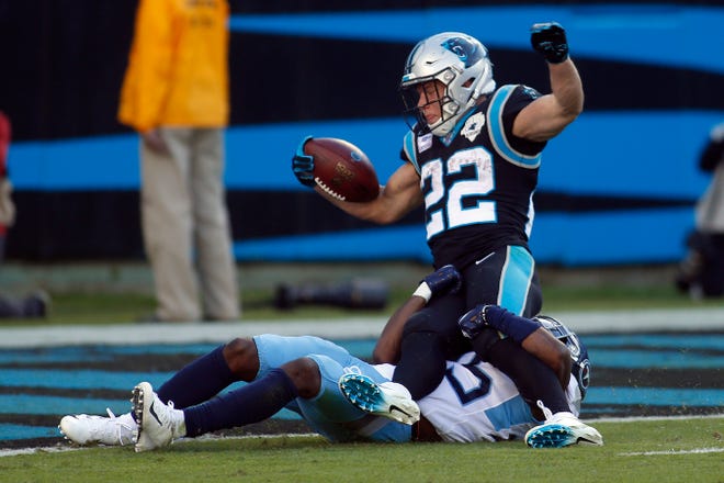 Carolina Panthers running back Christian McCaffrey (22) scores a touchdown while Tennessee Titans cornerback Adoree' Jackson (25) tackles in Charlotte, N.C., on Sunday. [Brian Blanco/The Associated Press]