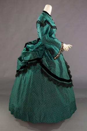 This circa 1868 printed silk polonaise dress was supported by a bustle and layers of other under garments. It's featured in Inside Out: Women's Fashion from Foundation to Silhouette, on view through Jan. 5 at the Flagler Museum. [Photo courtesy of Augusta Auctions]