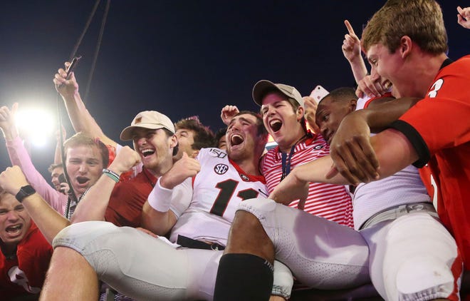 Georgia quarterback Jake Fromm (11) celebrates in the stands with fans after Georgia's 24-17 win over Florida in an NCAA college football game Saturday, Nov. 2, 2019, in Jacksonville, Fla. (Bob Andres/Atlanta Journal Constitution via AP)