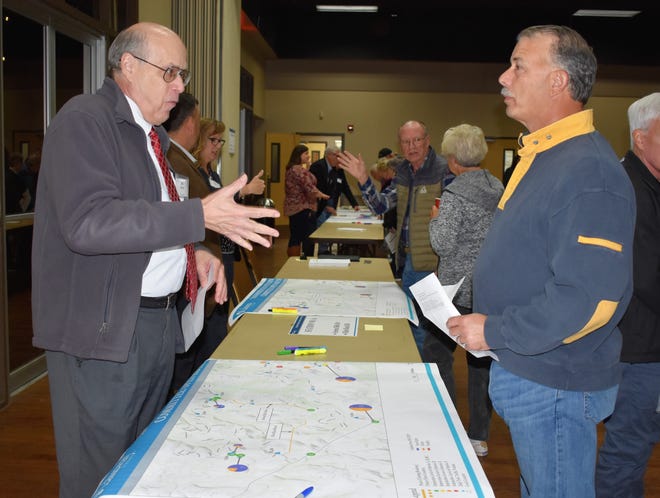 Jim Harvey, left, a member of the Transportation Study Team reviews a proposed project with Flint Rock Falls resident Lyn Mueller during an Oct. 29 open house. [PHOTO BY LESLEE BASSMAN]