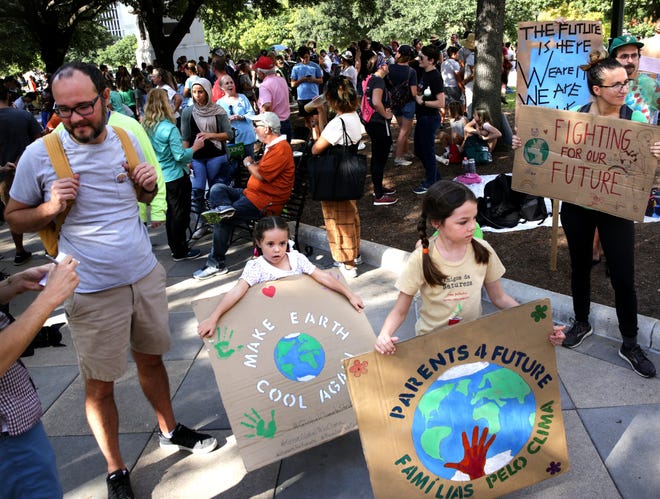 Alice Klafke, 5, left, and her sister Maria, 9, holds signs at the Capitol during a demonstration in September to call attention to climate change. [BRONTE WITTPENN/AMERICAN-STATESMAN]