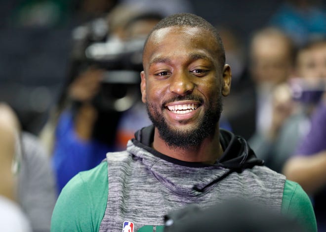 Celtics guard Kemba Walker smiles with friends as he makes his way onto the Charlotte Hornets' court before Thursday's game in Charlotte, N.C. Walker formerly played for the Hornets and signed with the Celtics during the offseason. [The Associated Press]