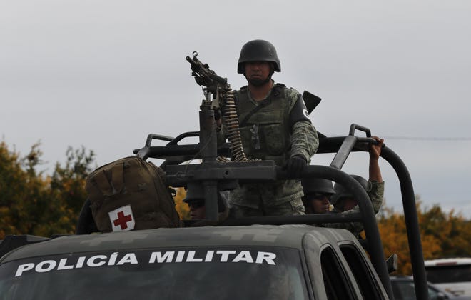 Mexican soldiers stand guard as members of an American family are laid to rest last week. They were among nine people killed by a drug cartel, a growing problem in Mexico, says columnist Bret Stephens. [MARCO UGARTE/ASSOCIATED PRESS]