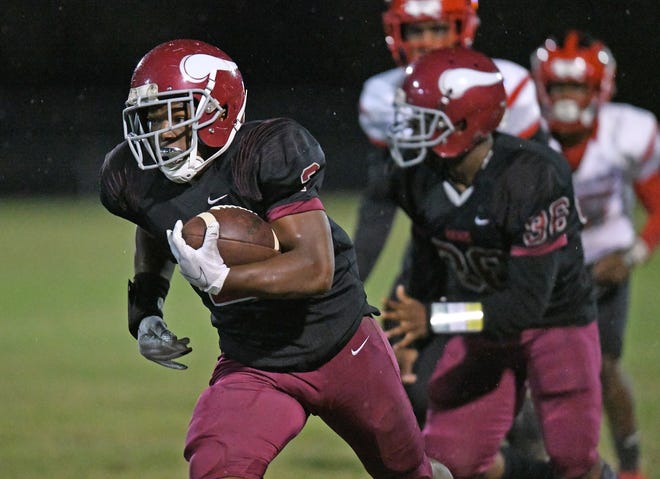 Raines running back Nigel Smith (2) sprints away from Westside defenders during a first quarter running play. [Bob Self/Florida Times-Union]