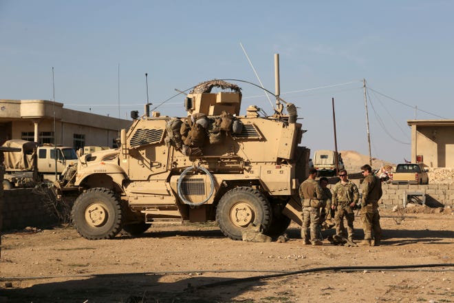U.S. Army soldiers stand outside their armored vehicle on a joint base with Iraqi army south of Mosul, Iraq in February 2017. Iraqi security officials said 17 Katyusha rockets hit an Iraqi air base south of the city of Mosul that houses American troops. The two officials said there are no immediate reports of casualties from the attack, which occurred on Friday. [KHALID MOHAMMED/THE ASSOCIATED PRESS (FILE)]