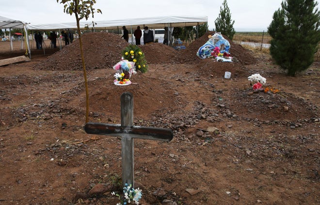 Freshly dug graves, top of photo, are prepared for Rhonita Miller, 30, and four of her young children Krystal and Howard, and twins Titus and Tiana, who were murdered by drug cartel gunmen, before their burial at a cemetery in LeBaron, Chihuahua state, Mexico, on Friday. A total of three women and six of their children, from the extended LeBaron family, were gunned down in a cartel ambush while traveling along Mexico's Chihuahua and Sonora state border on Monday. The graves in the foreground are not related to the burial of the Miller family. [MARCO UGARTE/THE ASSOCIATED PRESS]
