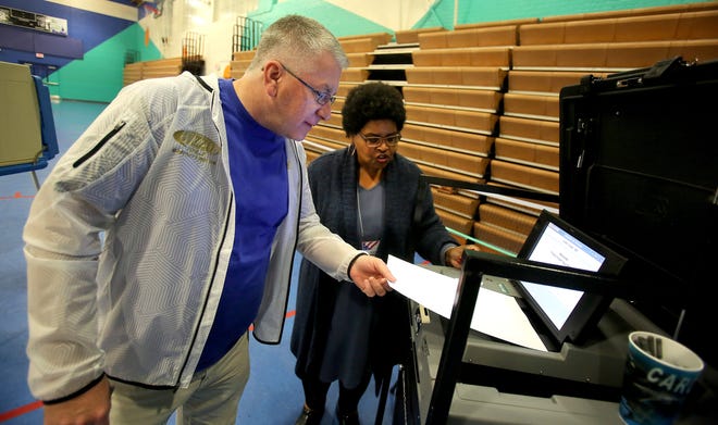 Paul Foster enters his ballot to be counted as Ursula Walls looks on at Shelby City Park on Tuesday. [Brittany Randolph/The Star]