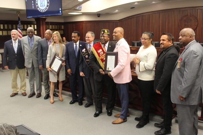 The Chatham County Commissioners honoring Master Sgt. G. John Parker (wearing a red sash) at their Friday meeting. [Nick Robertson/SavannahNow.com]