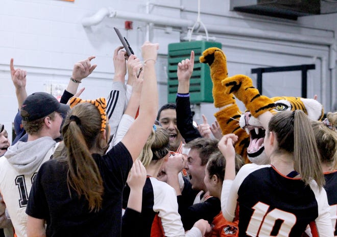 Illini Bluffs volleyball players wade into a throng of fans with their Class 1A sectional trophy on Wednesday at Wethersfield High School in Kewanee. [Troy E. Taylor]