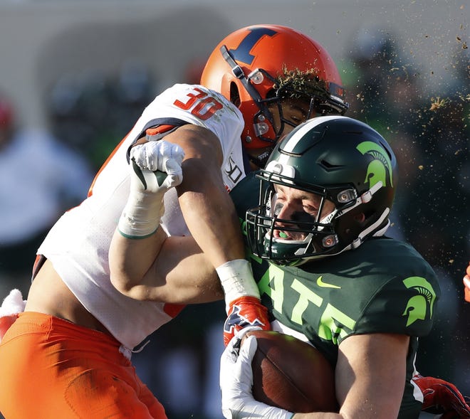 Michigan State tight end Matt Dotson is tackled by Illinois defensive back Sydney Brown (30) during the first half of Saturday's game in East Lansing, Mich. [AP Photo/Carlos Osorio]
