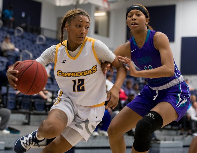 Gulf Coast's Ahlana Smith (12) tries to drive by Florida Southwestern State's Simone Lett during Saturday’s game at the Billy Harrison Field House. [JOSHUA BOUCHER/THE NEWS HERALD]